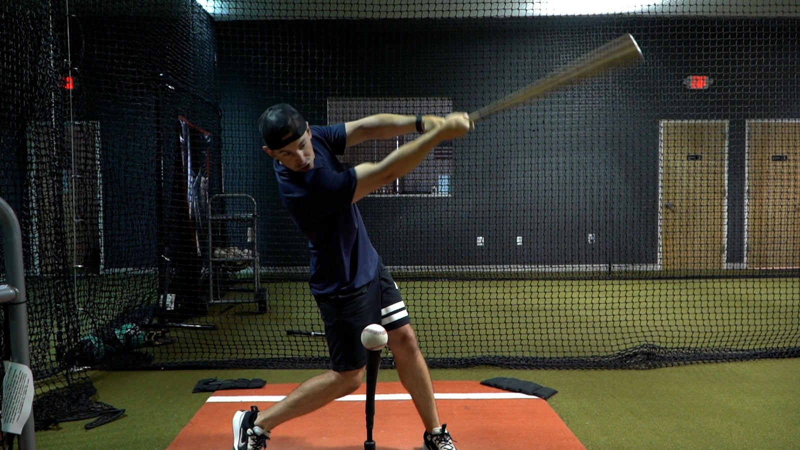 A LevelX player driving a ball off the tee in the cage